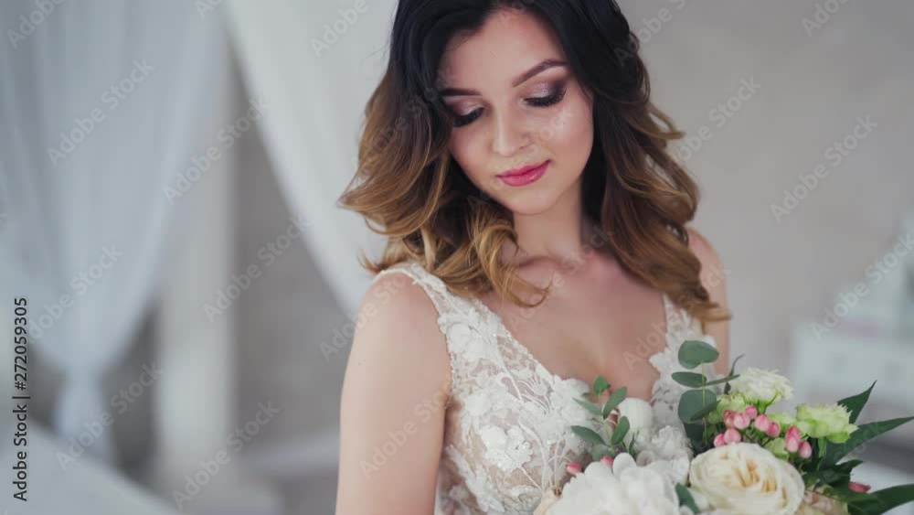Wedding bouquet of creamy roses in the hands of a beautiful bride. Lovely young woman dressed in white wedding dress is holding flowers. Close-up. Wedding bouquet of creamy roses in the hands of a beautiful bride. Lovely young woman dressed in white wedding dress is holding flowers. Close-up.