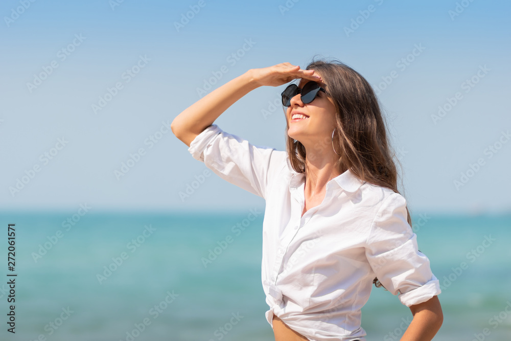 woman in sunglasses is smiling over blue sky. woman in sunglasses is smiling over blue sky.