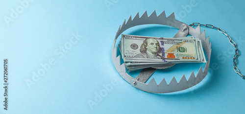 Trap with a stack of money. Dangerous risk for investment or deception in business. Blue background. photo