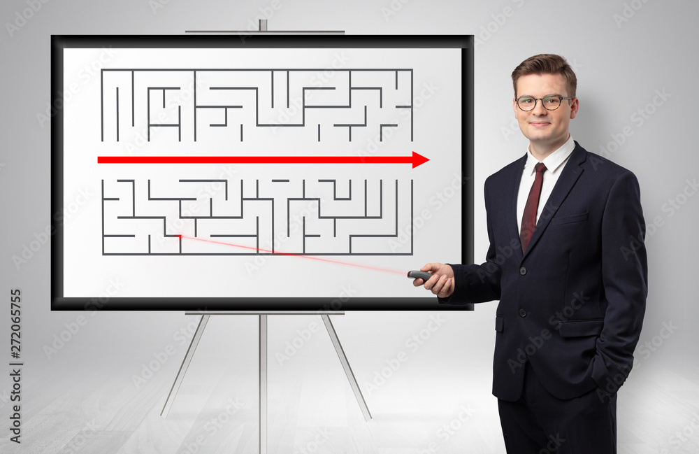 Handsome businessman with laser pointer presenting potential exit from a labyrinth
Handsome businessman with laser pointer presenting potential exit from a labyrinth