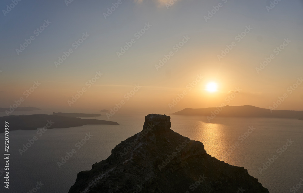 Beautiful sunset over rock formation on Greek island Santorini in the mediterranean sea