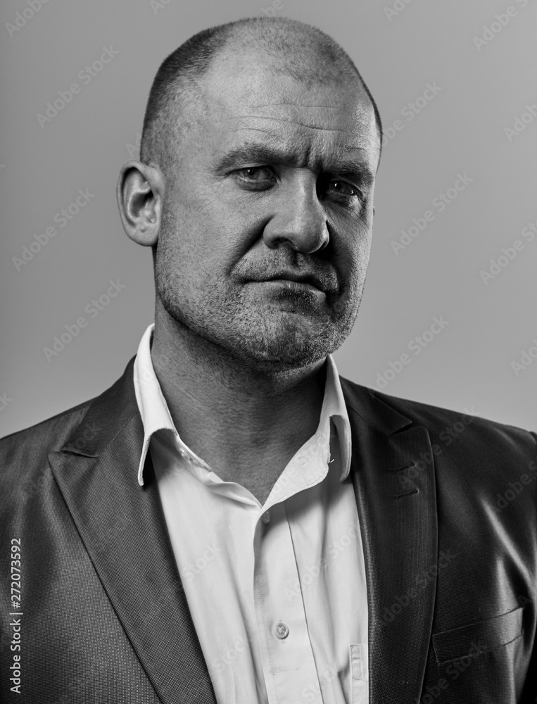Serious angry man in suit looking. Portrait of actor on grey background. Emotional natural portrait. Closeup. Serious angry man in suit looking. Portrait of actor on grey background. Emotional natural portrait. Closeup.