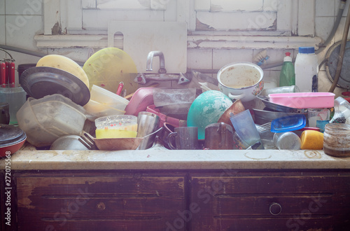 фотографія Pile of abandoned dirty utensils in a kitchen washbasin