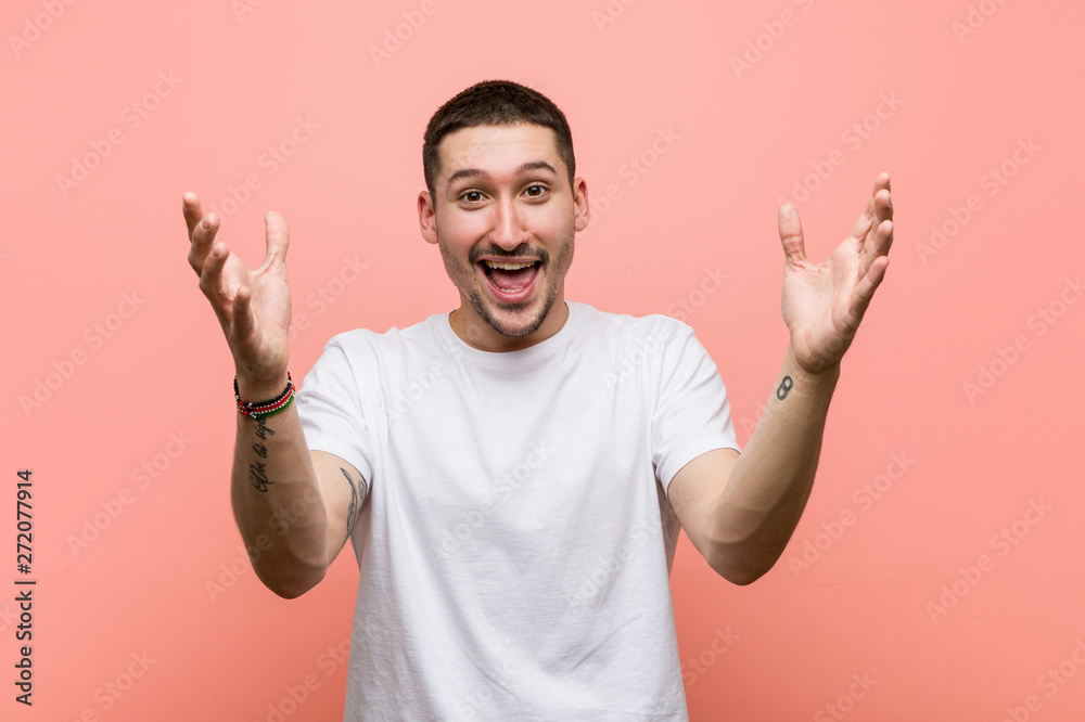 Young casual man receiving a pleasant surprise, excited and raising hands. Young casual man receiving a pleasant surprise, excited and raising hands.