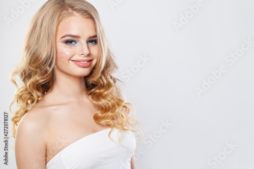 Beautiful blonde woman with long healthy curly hair and clear skin. Fashion girl smiling