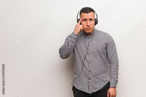 Young latin man listening to music thinking about an idea