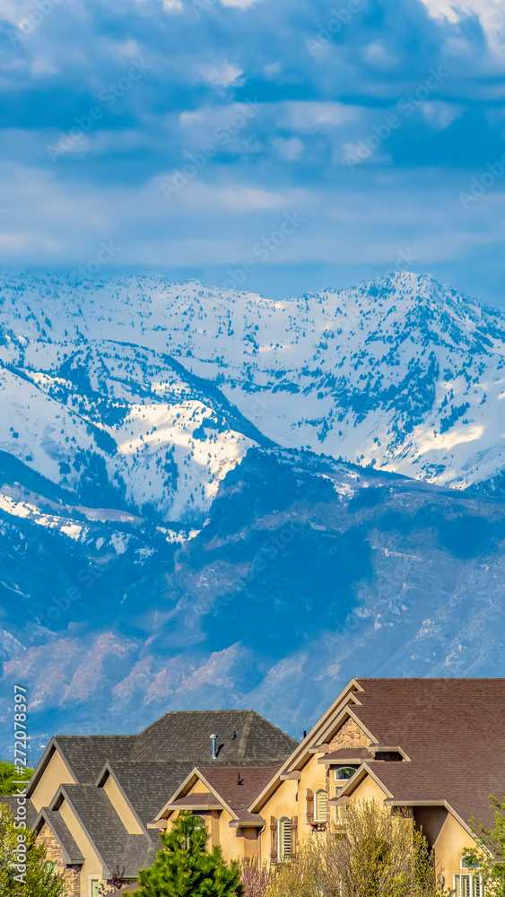 Panorama Houses and lush green trees with snow capped mountain in the background Panorama Houses and lush green trees with snow capped mountain in the background