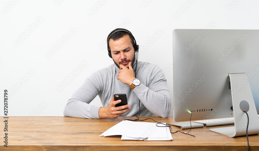 Telemarketer Colombian man thinking and sending a message Telemarketer Colombian man thinking and sending a message