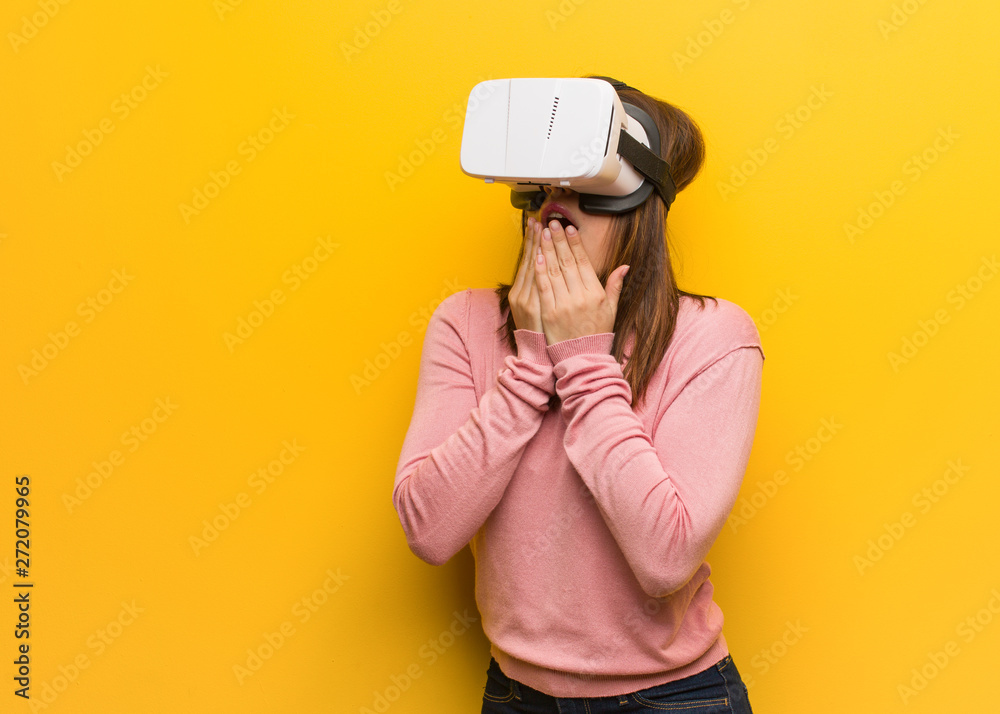 Young cute woman wearing a virtual reality googles biting nails, nervous and very anxious Young cute woman wearing a virtual reality googles biting nails, nervous and very anxious