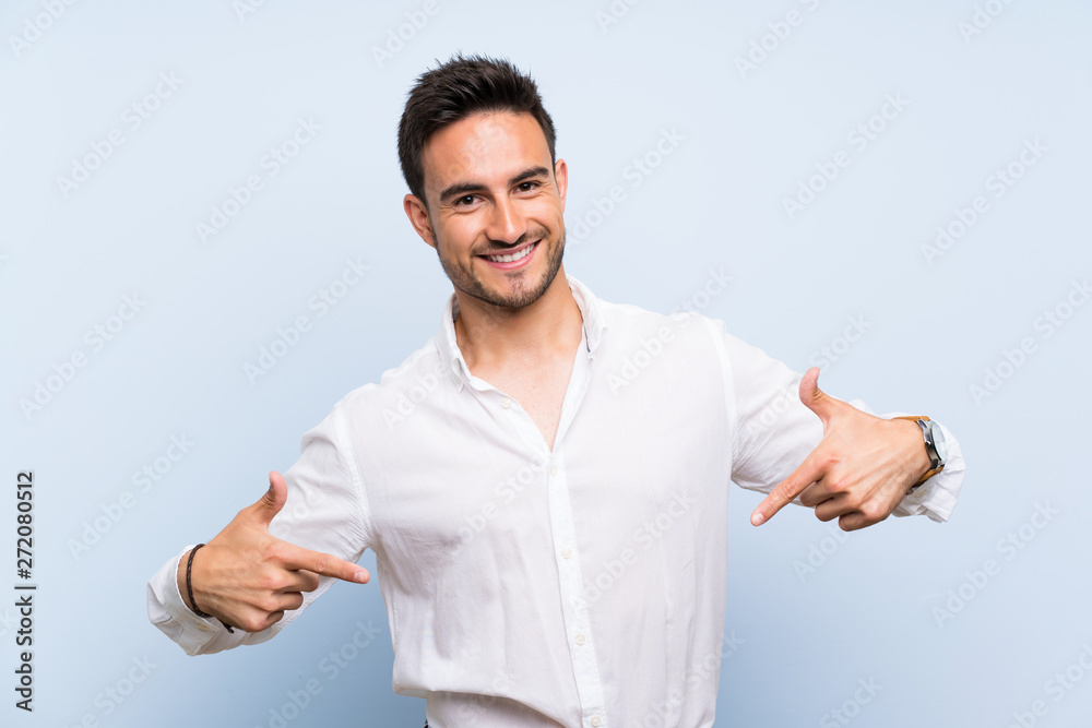 Handsome young man over isolated blue background proud and self-satisfied Handsome young man over isolated blue background proud and self-satisfied