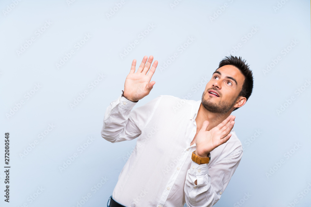 Handsome young man over isolated blue background nervous and scared Handsome young man over isolated blue background nervous and scared