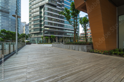 Empty wooden footpath front modern building. © hallojulie