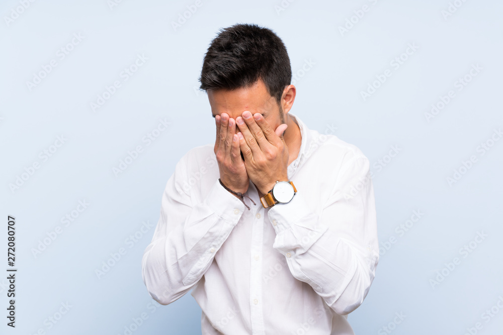 Handsome young man over isolated blue background with tired and sick expression Handsome young man over isolated blue background with tired and sick expression