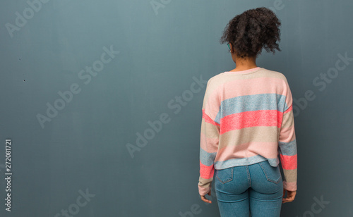 Young african american girl with blue eyes from behind, looking back photo