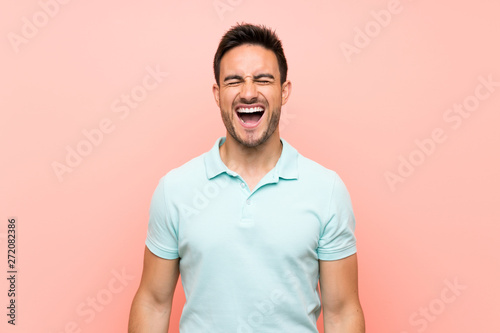 Handsome young man over isolated background shouting to the front with mouth wide open