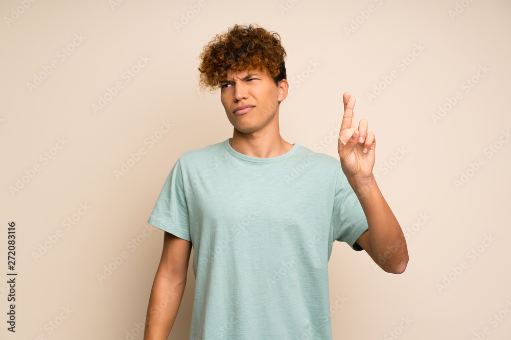 African american man with green shirt with fingers crossing and wishing the best African american man with green shirt with fingers crossing and wishing the best