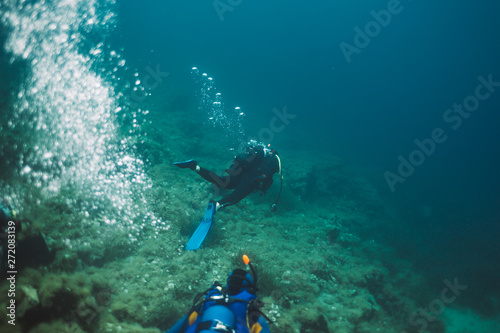Rear view of two scuba divers diving underwater © yossarian6
