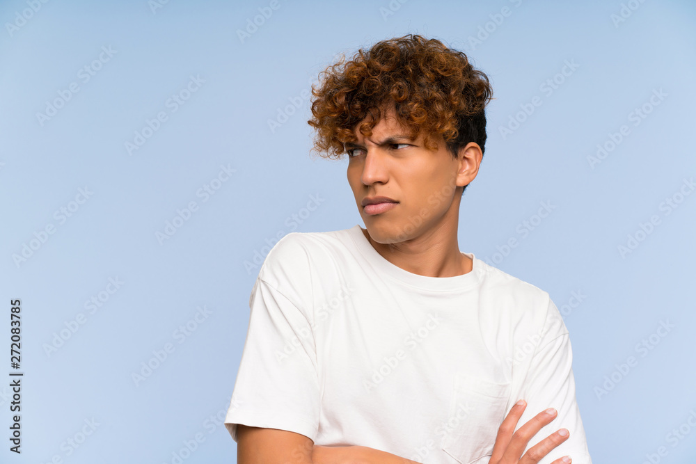 Young african american man with white shirt standing and thinking an idea Young african american man with white shirt standing and thinking an idea