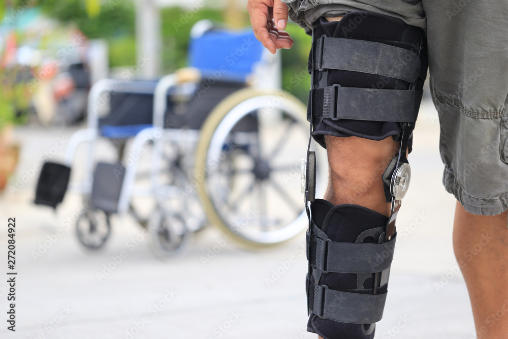 Senior man wear knee support brace on leg standing at the road