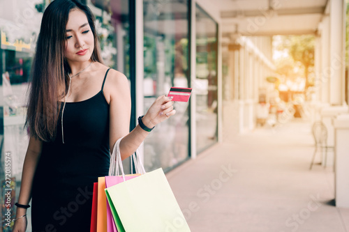 Close up hand of women holding credit card and shopping bags at shopping mall.