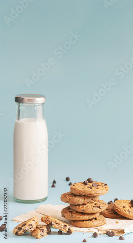 Cookies with chocolate chips and fresh milk bottles on the ground  light blue pastel colors