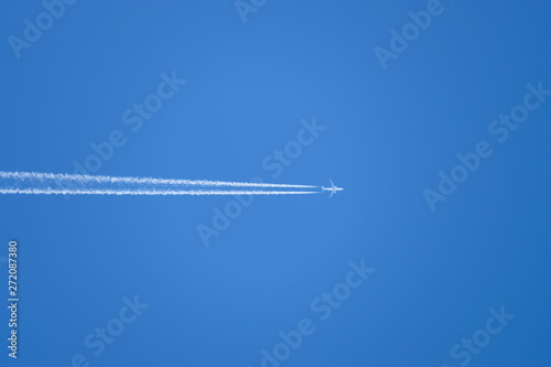 Condensation trail from an airplane in a blue sky. flying a passenger plane.