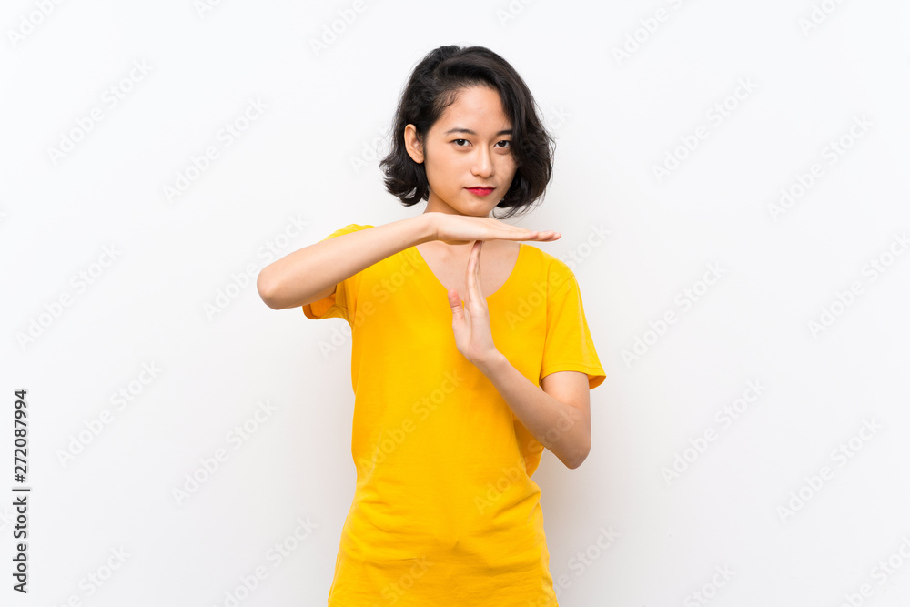 Asian young woman over isolated white background making time out gesture Asian young woman over isolated white background making time out gesture