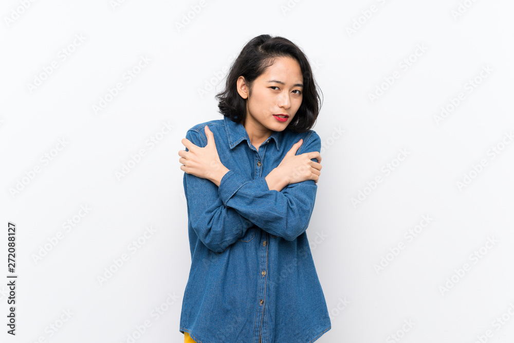 Asian young woman over isolated white background freezing Asian young woman over isolated white background freezing