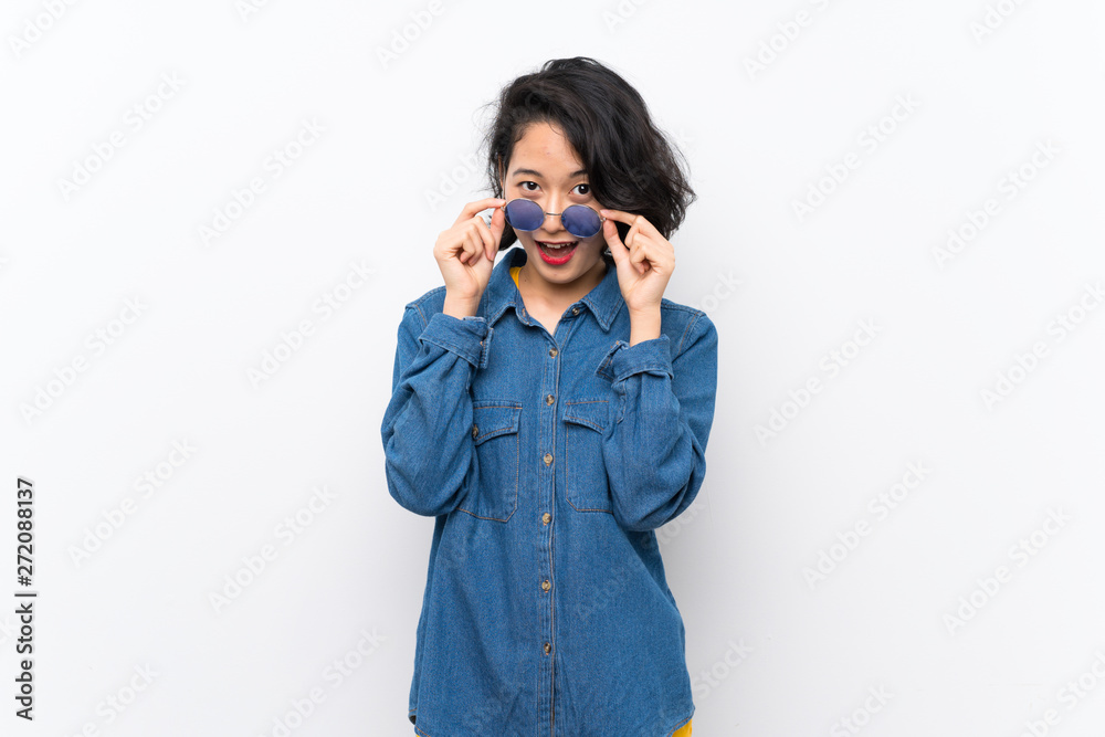Asian young woman over isolated white background with glasses and surprised Asian young woman over isolated white background with glasses and surprised