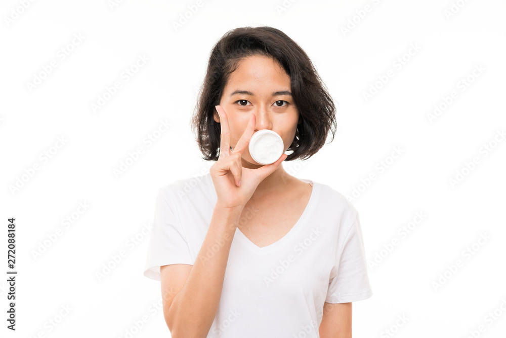 Asian young woman over isolated background with moisturizer Asian young woman over isolated background with moisturizer