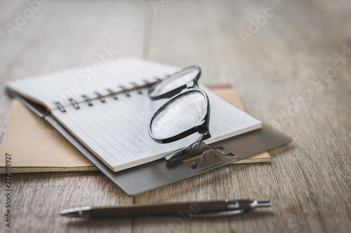 Selective focus of Pen, notebook, glasses on the table