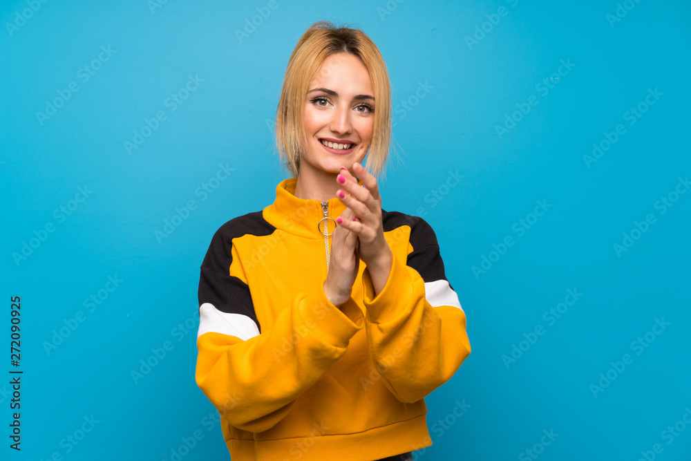 Young blonde woman over isolated blue background applauding Young blonde woman over isolated blue background applauding
