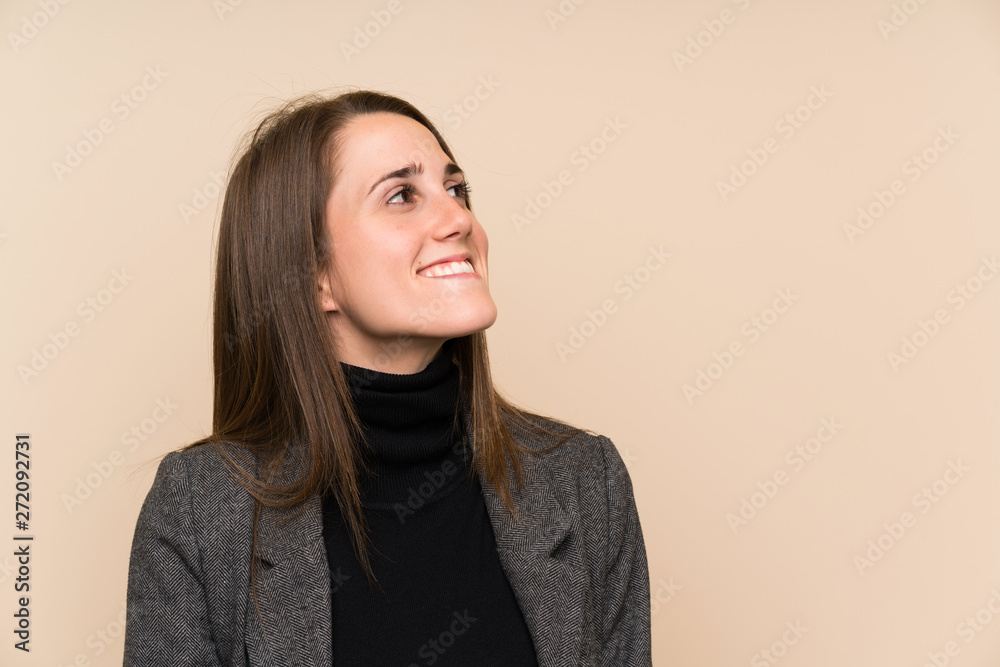 Young woman over isolated wall laughing and looking up Young woman over isolated wall laughing and looking up