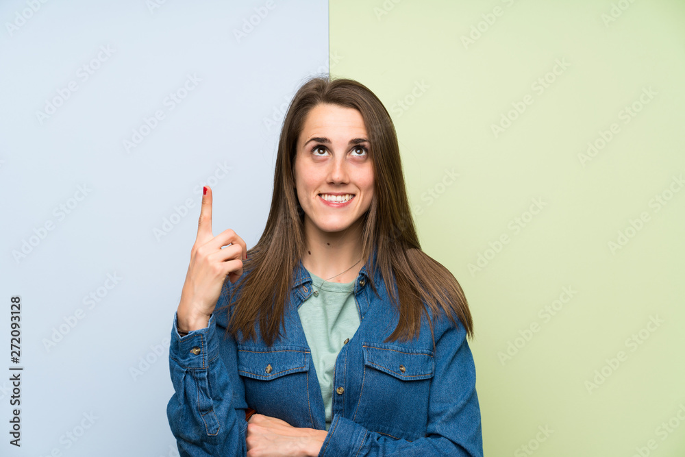 Young woman over colorful background pointing with the index finger a great idea Young woman over colorful background pointing with the index finger a great idea