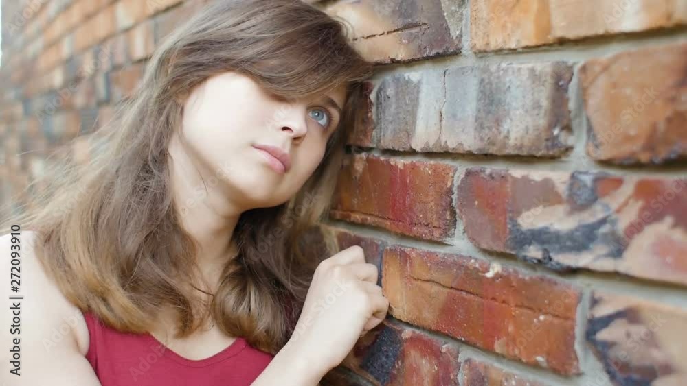 young cute beautiful girl near the red brick wall smilng and flirting, dreamy romantic woman walking outdoors, female emotions, positive mood, happiness young cute beautiful girl near the red brick wall smilng and flirting, dreamy romantic woman walking outdoors, female emotions, positive mood, happiness