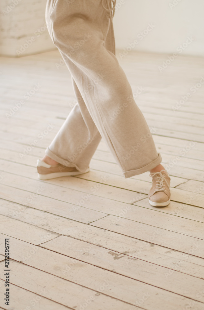 Women's legs in beige trousers. Dancing, delicate photography.