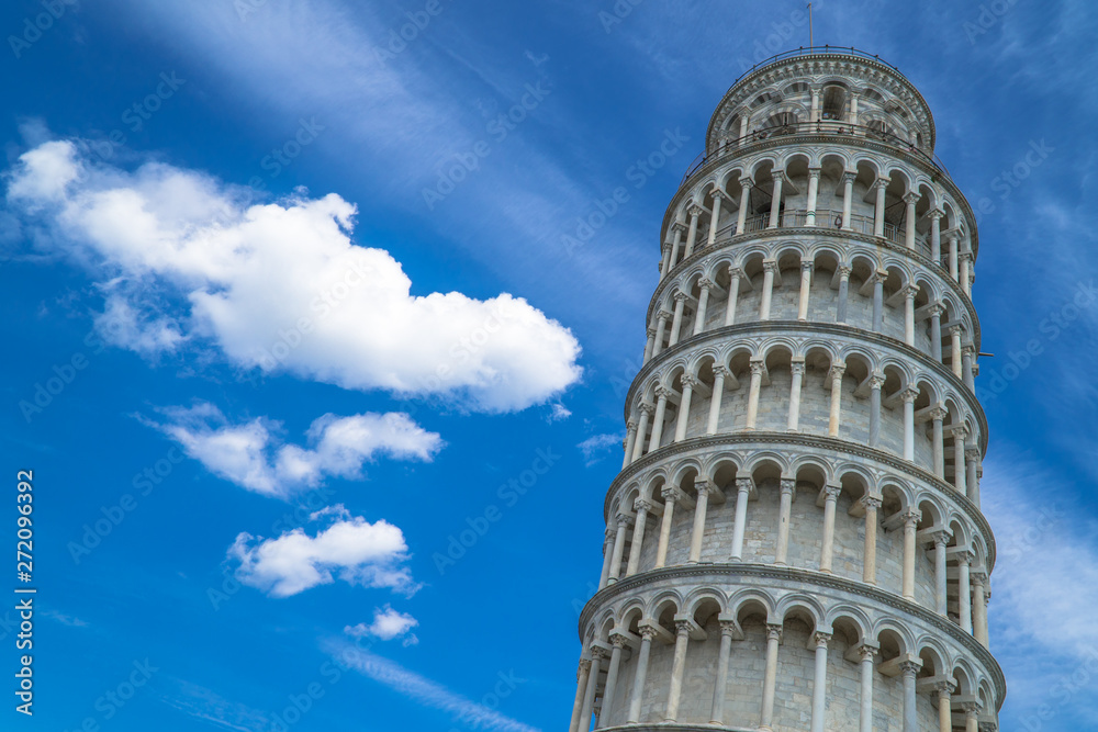 Pisa, Tuscany / Italy - April 18th, 2019: Low angle of the Leaning Tower of Pisa with blue sky and white clouds in the background.
