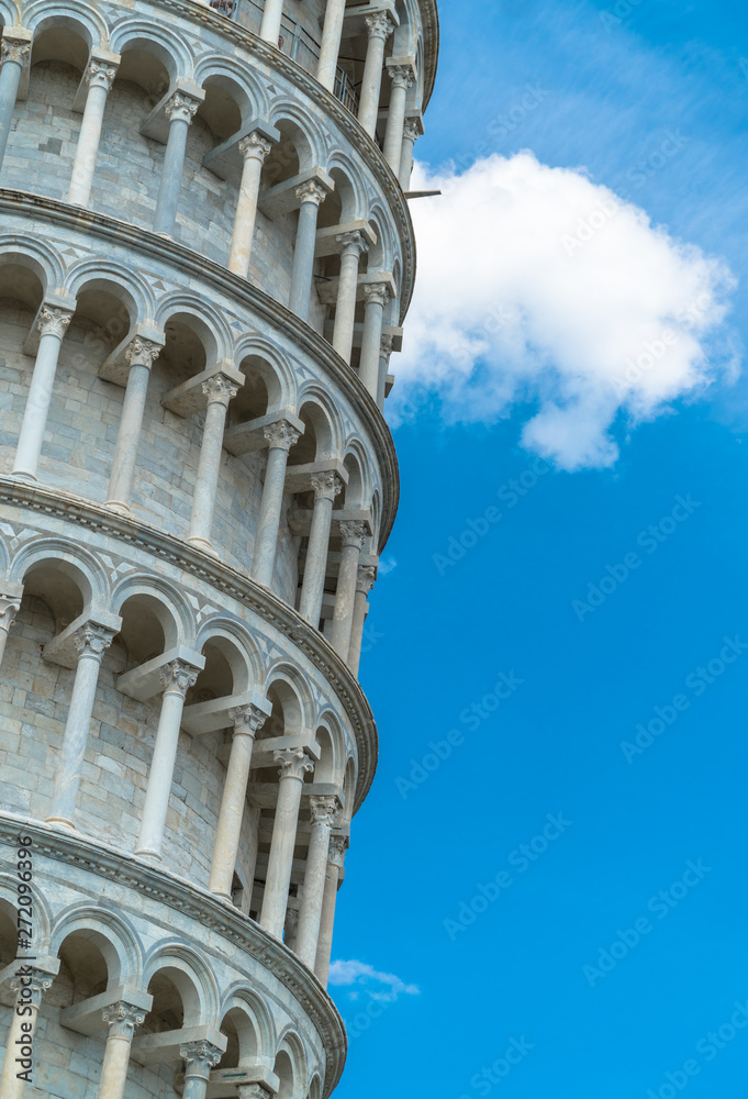 Pisa, Tuscany / Italy - April 18th, 2019: Close-up of the Leaning Tower of Pisa with blue sky and white clouds in the background.
