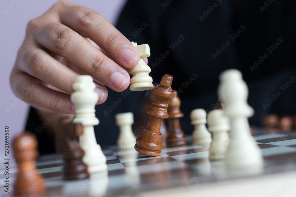 Close up shot hand of business woman playing the chess board to win by killing the king of opponent metaphor business competition winner and loser select focus shallow depth of field Close up shot hand of business woman playing the chess board to win by killing the king of opponent metaphor business competition winner and loser select focus shallow depth of field