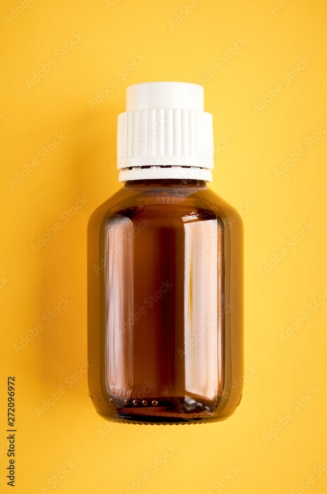 Fototapeta premium Syrup in glass bottle composition on yellow background