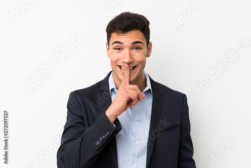 Handsome man over isolated white wall doing silence gesture