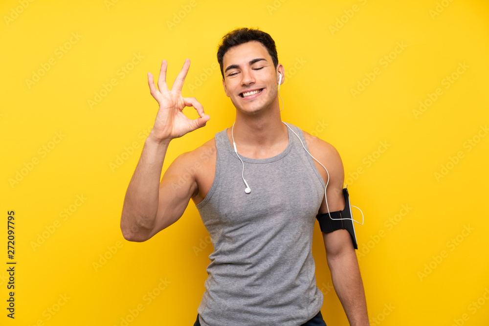 Handsome sport man over isolated background showing ok sign with fingers Handsome sport man over isolated background showing ok sign with fingers
