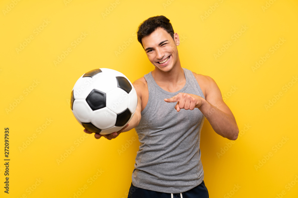 Handsome sport man over isolated background with a soccer ball Handsome sport man over isolated background with a soccer ball