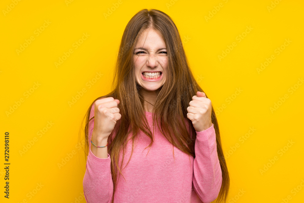 Young woman with long hair over isolated yellow wall frustrated by a bad situation