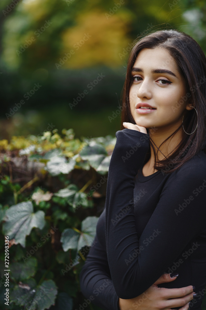 brunette girl walking through the park in Chicago during fall brunette girl walking through the park in Chicago during fall
