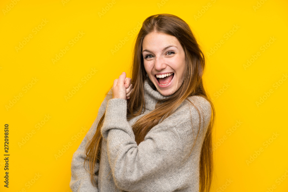 Young woman with long hair over yellow background celebrating a victory Young woman with long hair over yellow background celebrating a victory