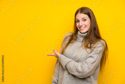 Young woman with long hair over yellow background extending hands to the side for inviting to come