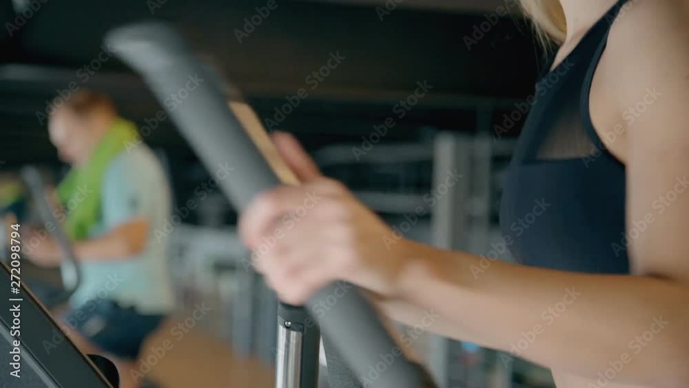 Lady making workout on orbitrek in gym Lady making workout on orbitrek in gym