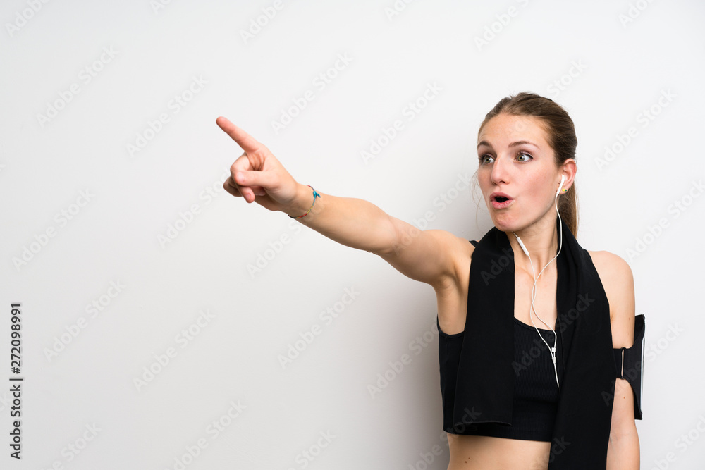Young sport woman over isolated white background pointing away Young sport woman over isolated white background pointing away