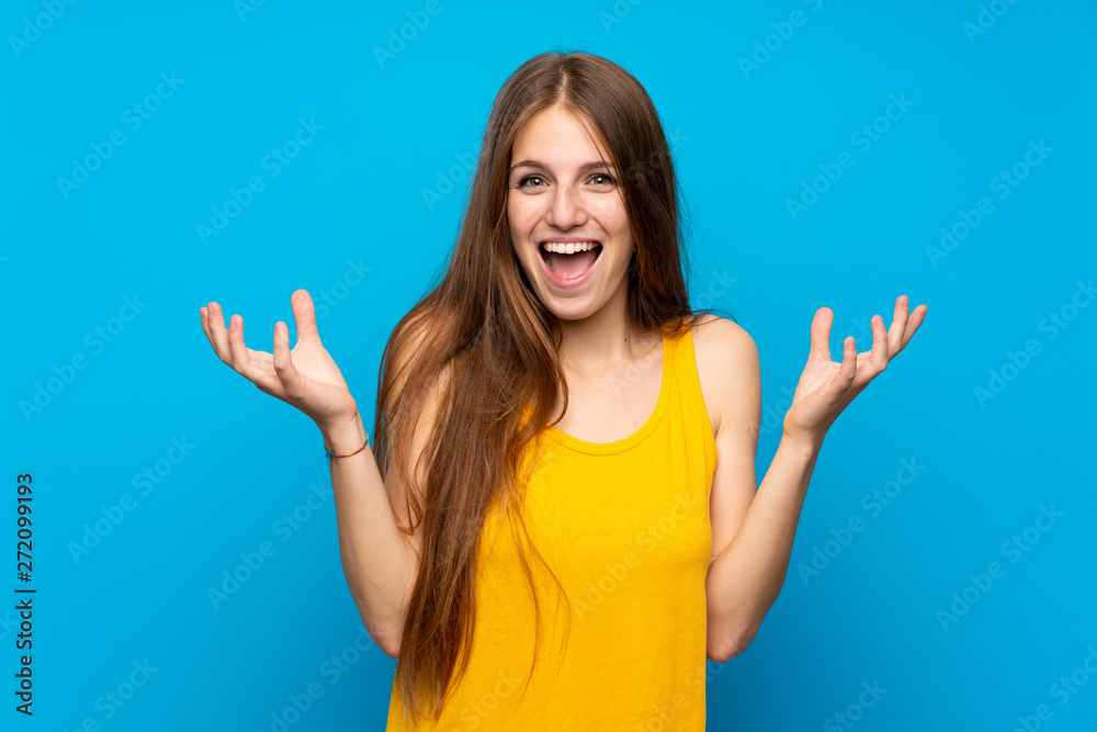 Young woman with long hair over isolated blue wall smiling a lot Young woman with long hair over isolated blue wall smiling a lot